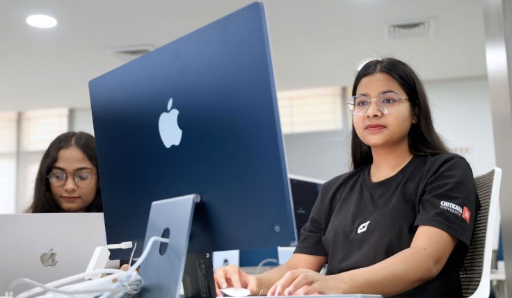 A student using an Apple computer system to study concepts from her BCom course, focusing on business and financial analysis.