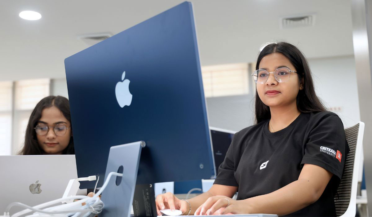 A student using an Apple computer system to study concepts from her BCom course, focusing on business and financial analysis.