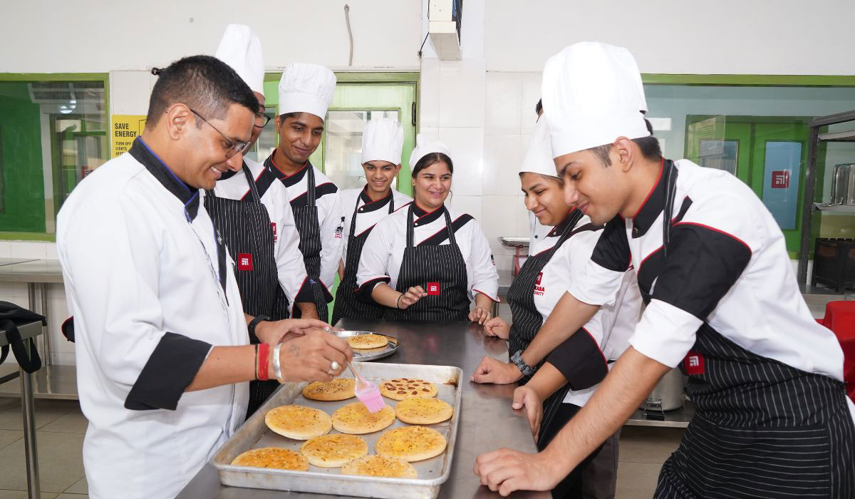 Students in chef uniforms preparing gourmet dishes as part of their B.Sc in Hospitality Administration for Career Success.